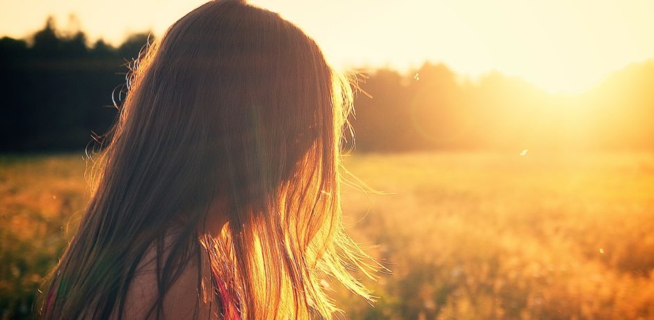 Frau vor der untergehenden Sonne